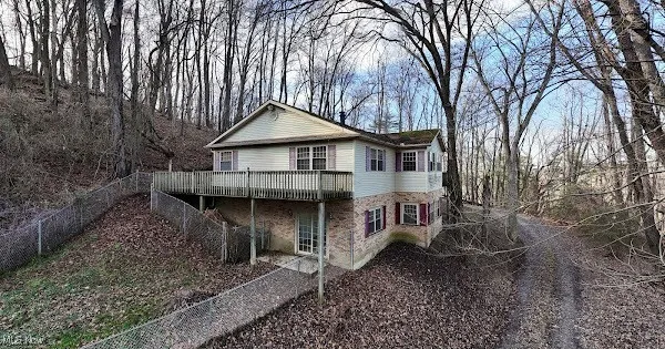 View of front of house with a wooden deck and brick siding