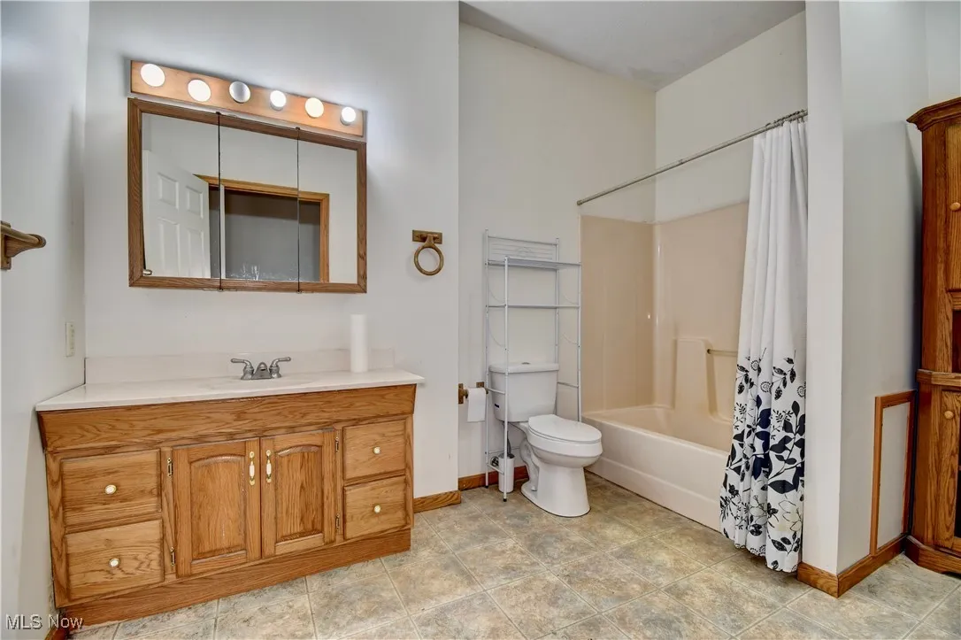 Full bathroom with vanity and shower / bath combo with shower curtain