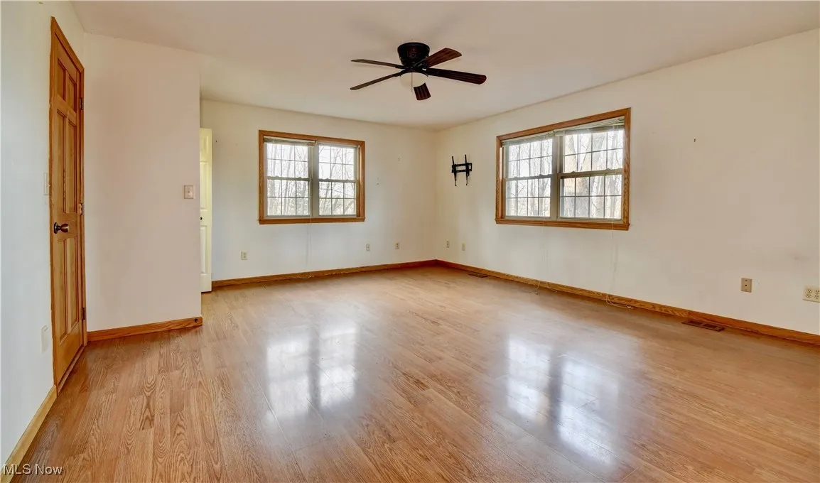Empty room with light wood finished floors and ceiling fan