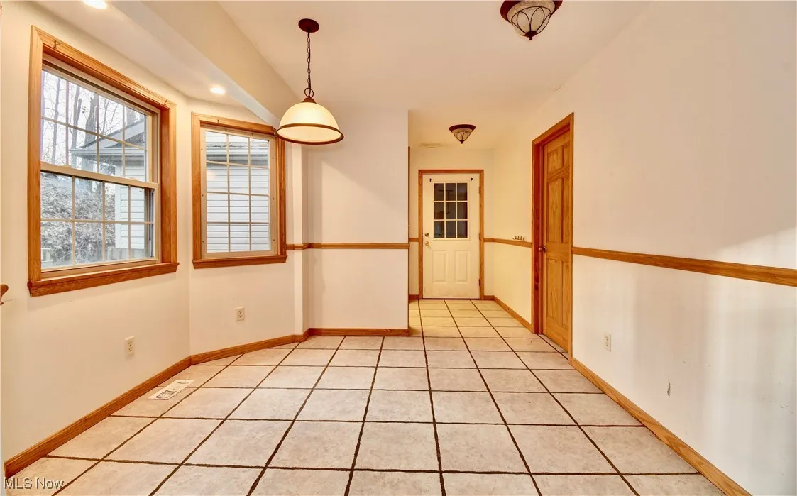 Unfurnished dining area with light tile patterned floors and recessed lighting