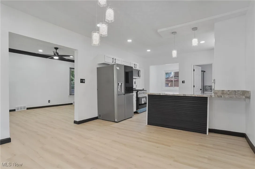 Kitchen with appliances with stainless steel finishes, light wood-type flooring, plenty of natural light, ceiling fan, and recessed lighting