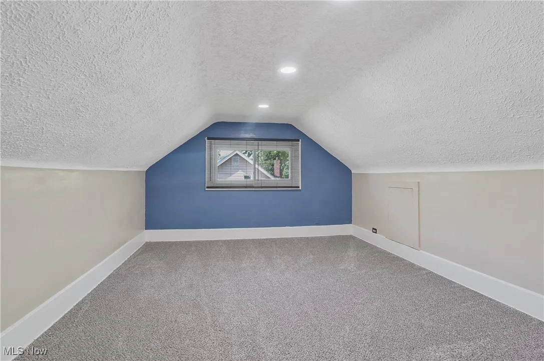 Bonus room with a textured ceiling, carpet floors, lofted ceiling, and recessed lighting