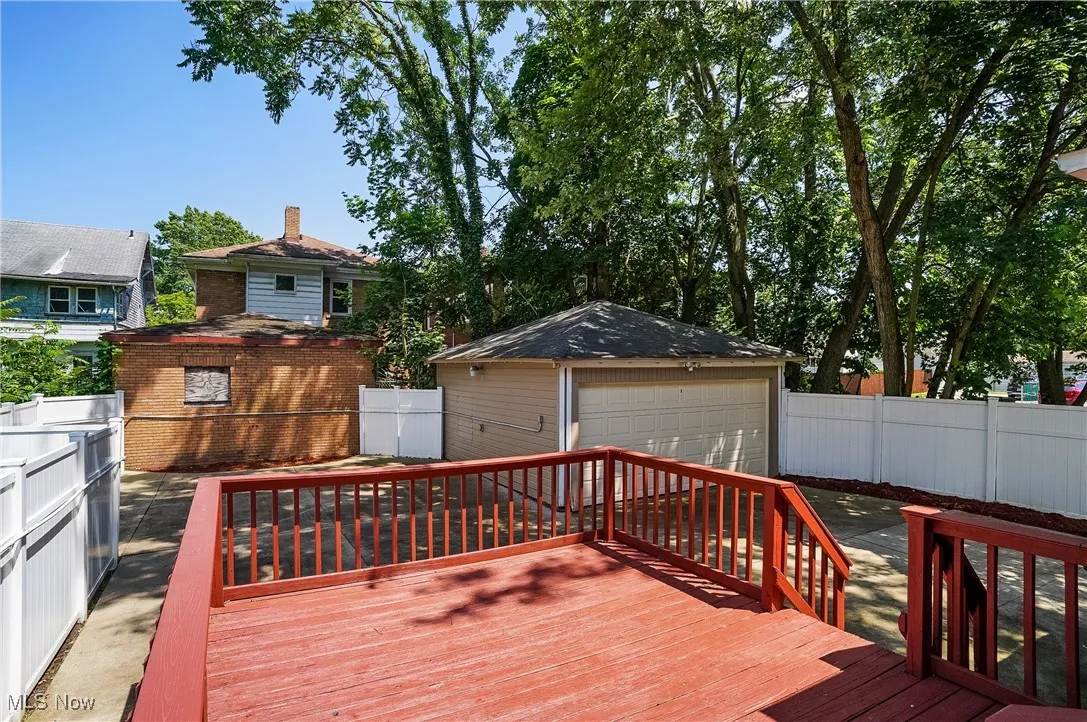 Deck featuring a detached garage, an outdoor structure, and a fenced backyard