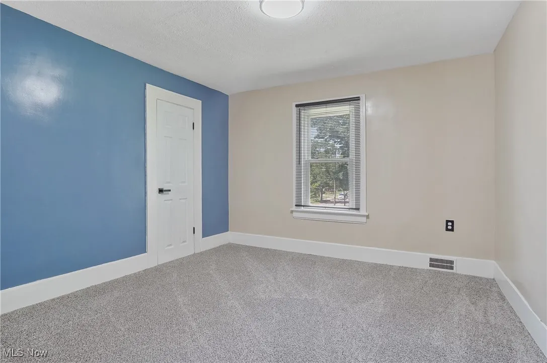 Empty room featuring carpet floors and a textured ceiling