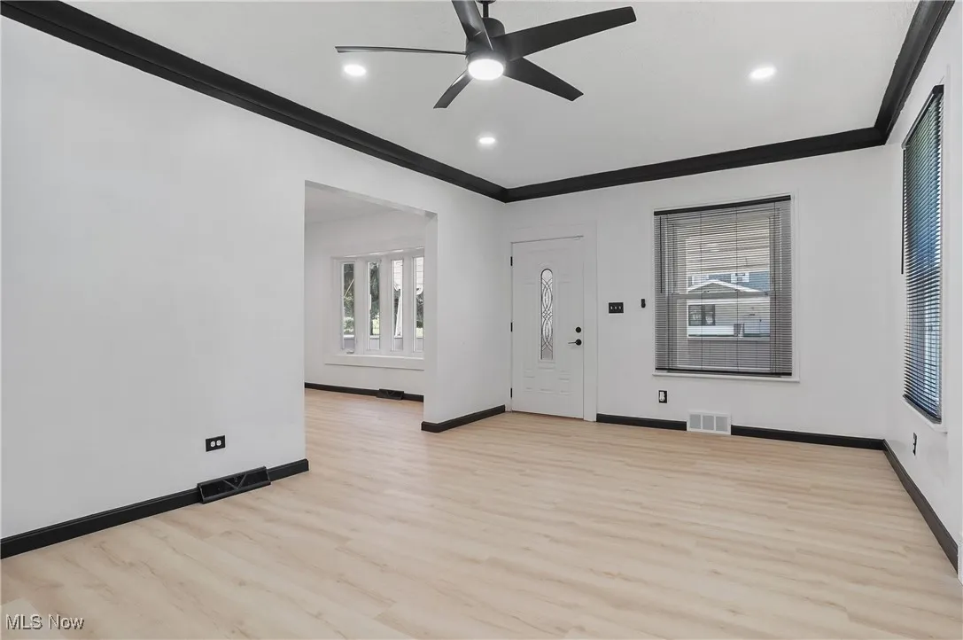 Foyer with ornamental molding, ceiling fan, light wood-style floors, and recessed lighting