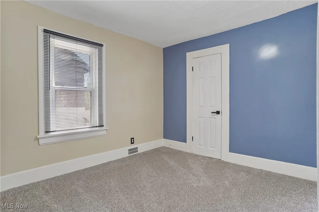 Carpeted empty room featuring baseboards