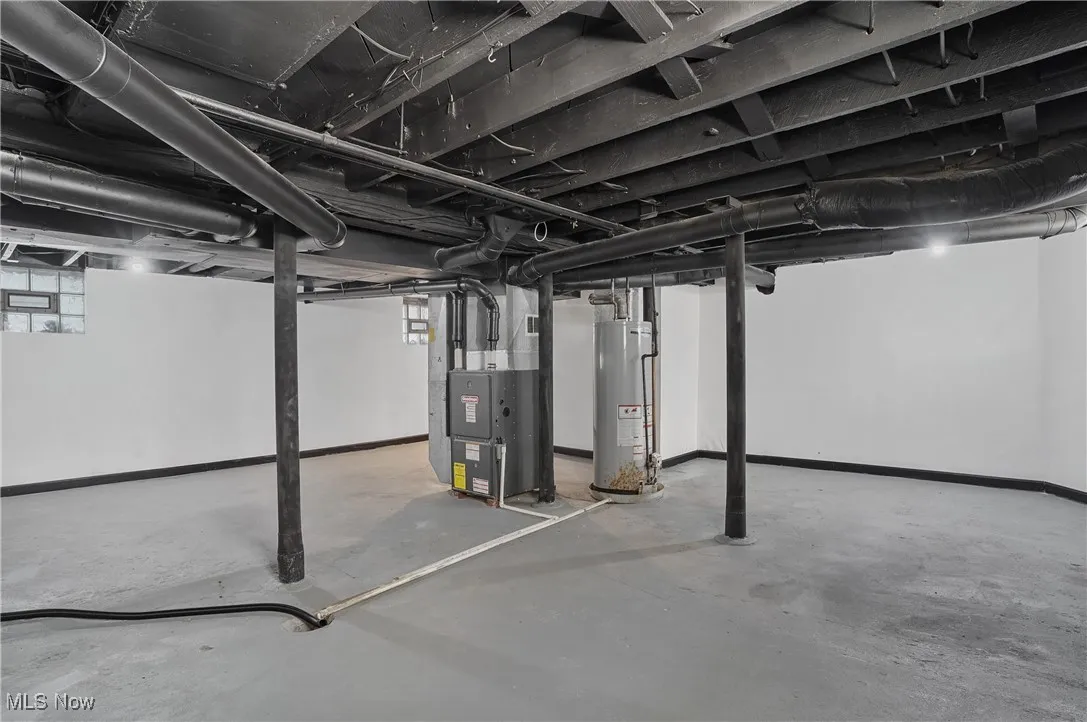 Below grade area featuring water heater and heating unit