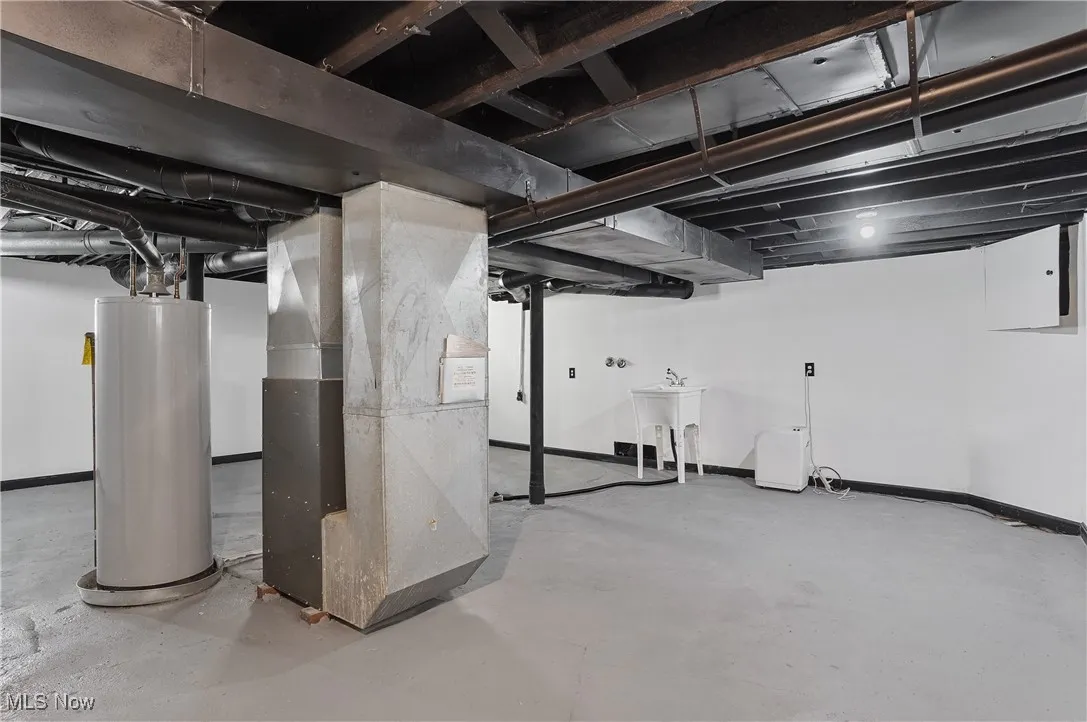 Basement featuring water heater and heating unit