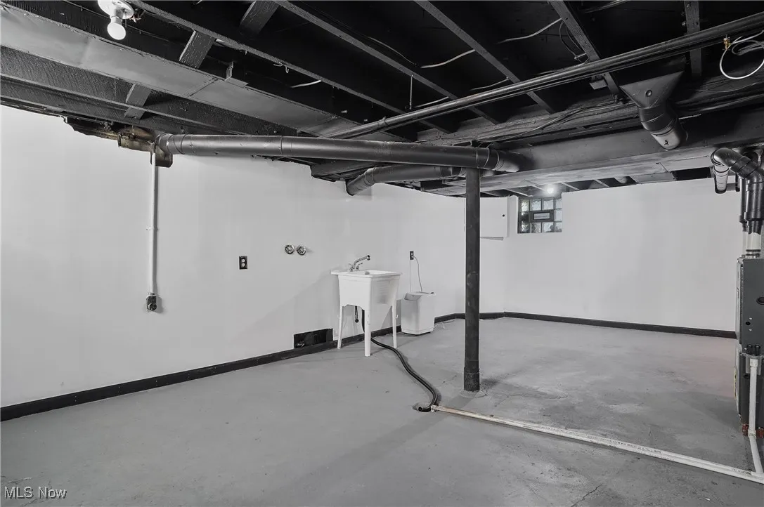 Below grade area featuring baseboards and a sink