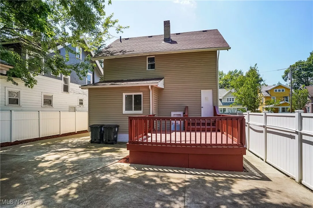 Rear view of property with a wooden deck, a patio area, a fenced backyard, and a chimney