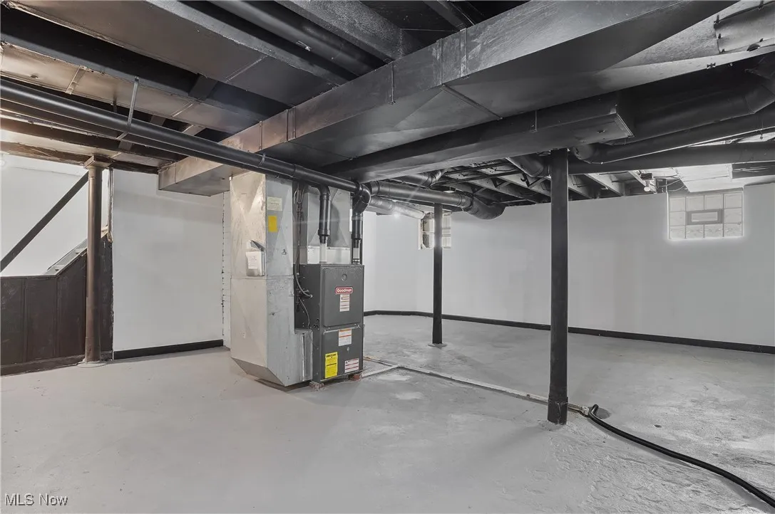 Basement featuring heating unit and baseboards