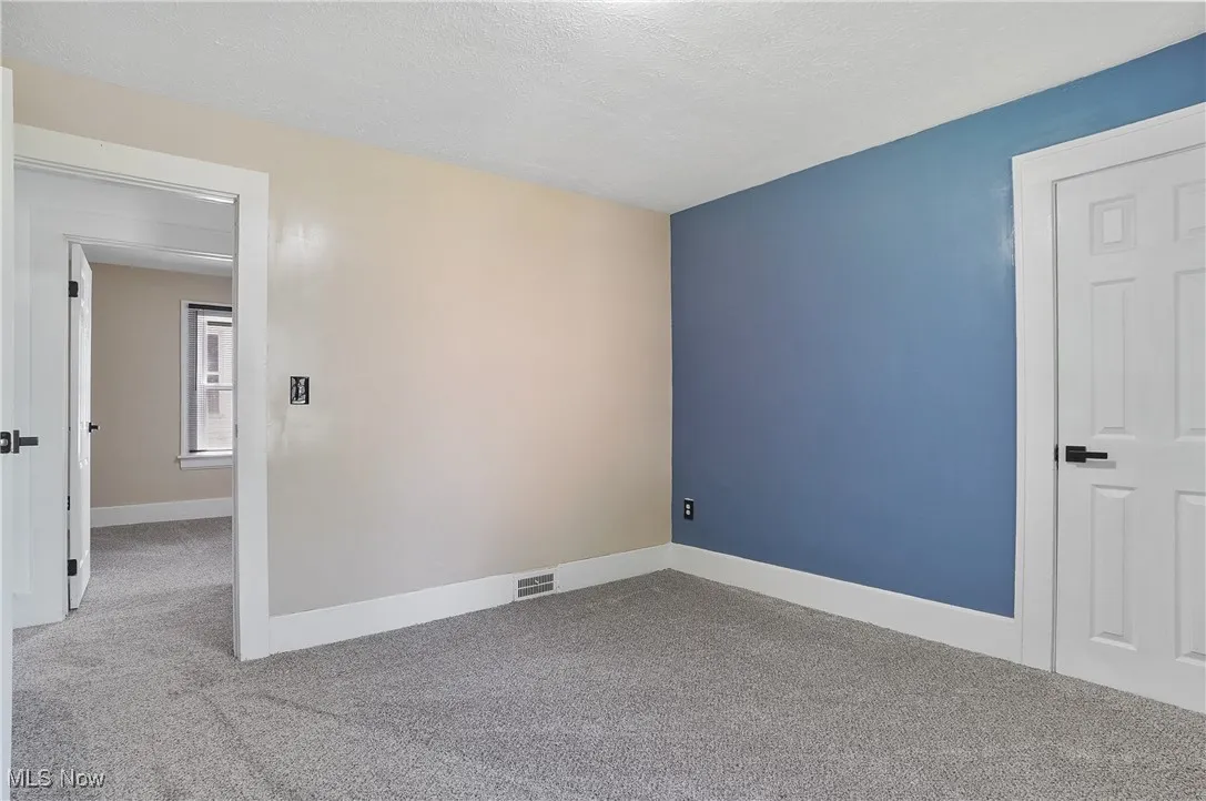 Unfurnished room with carpet flooring and a textured ceiling