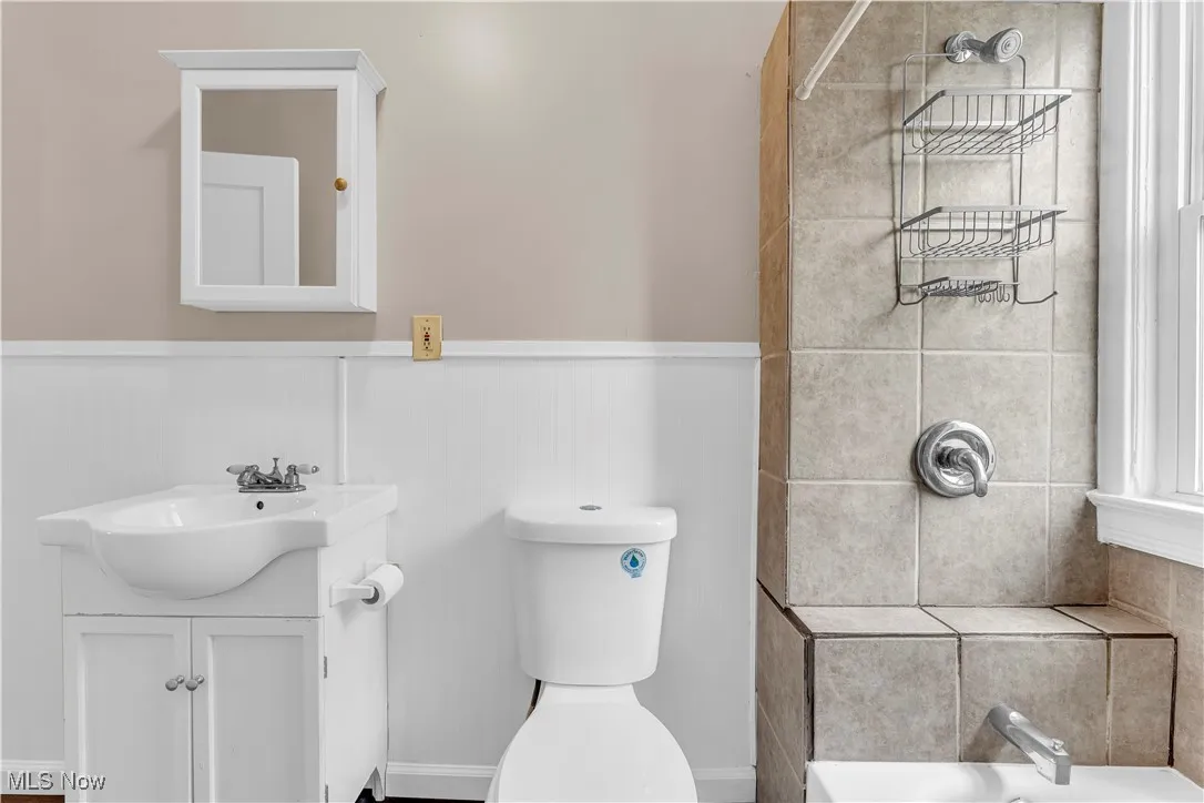 Bathroom with wainscoting, vanity, a shower, and a bath
