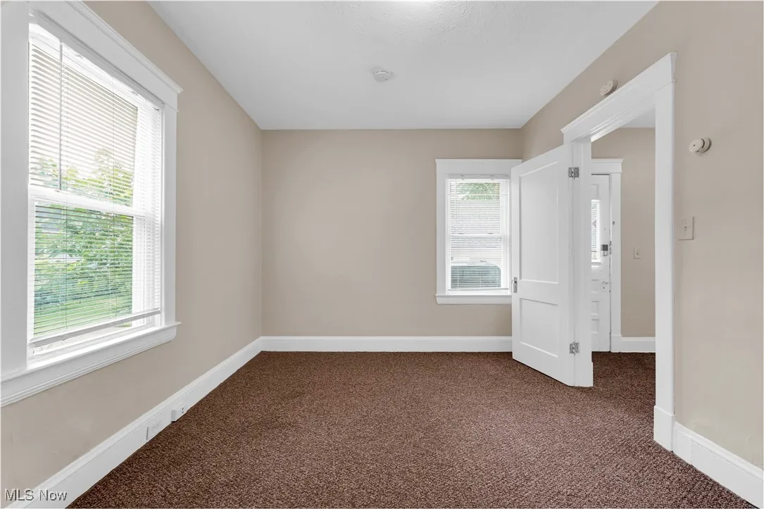Carpeted spare room with a smoke detector