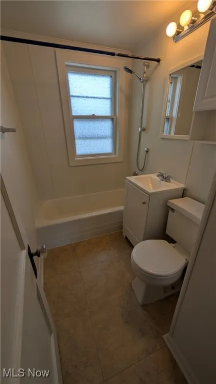 Full bath featuring washtub / shower combination, vanity, tile patterned flooring, and crown molding