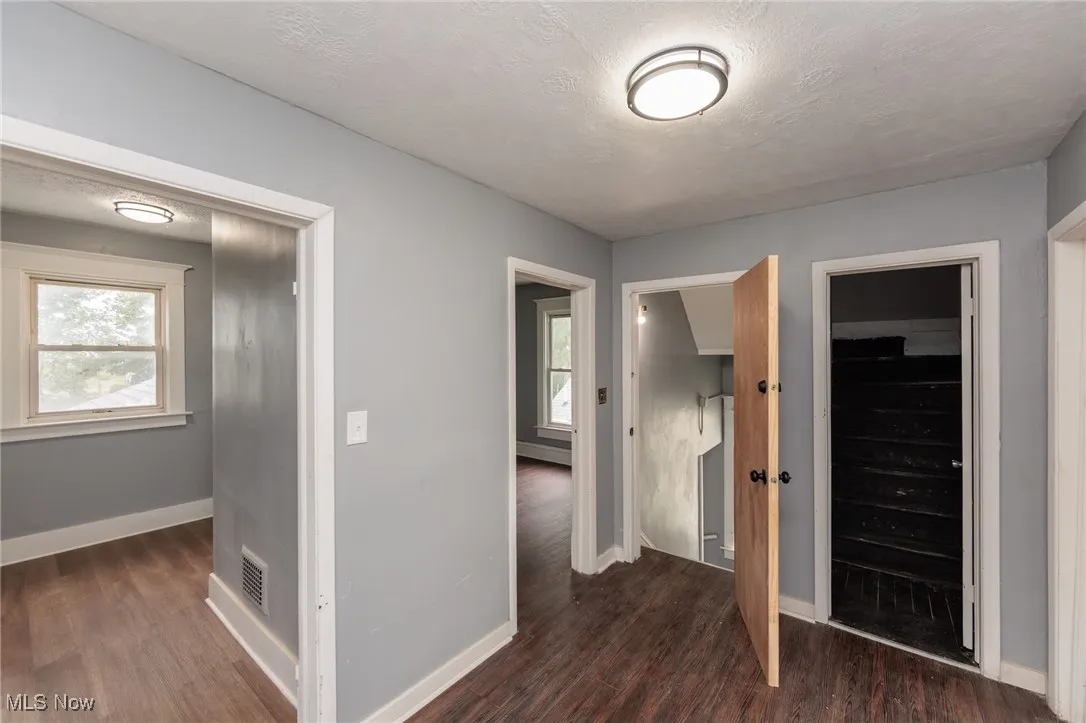 Unfurnished bedroom with dark wood-style floors and a textured ceiling