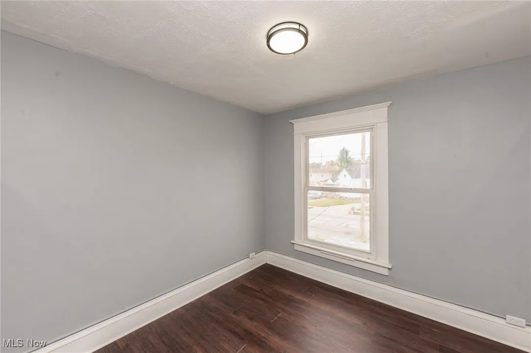 Spare room with dark wood-style flooring and a textured ceiling