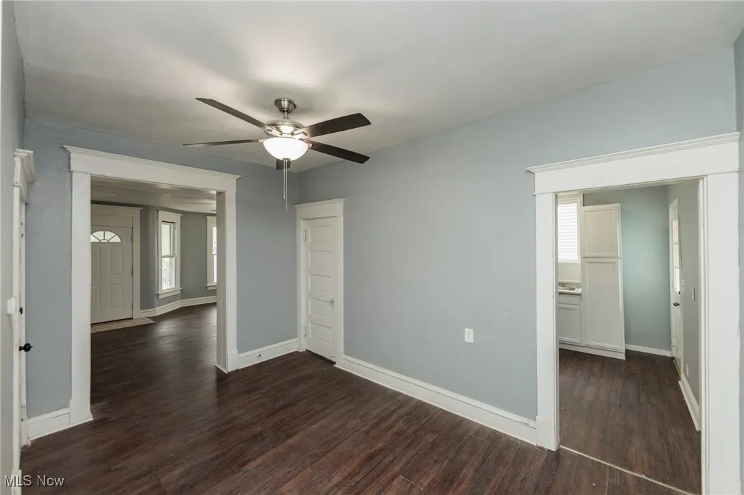 Unfurnished bedroom with dark wood-type flooring and ceiling fan