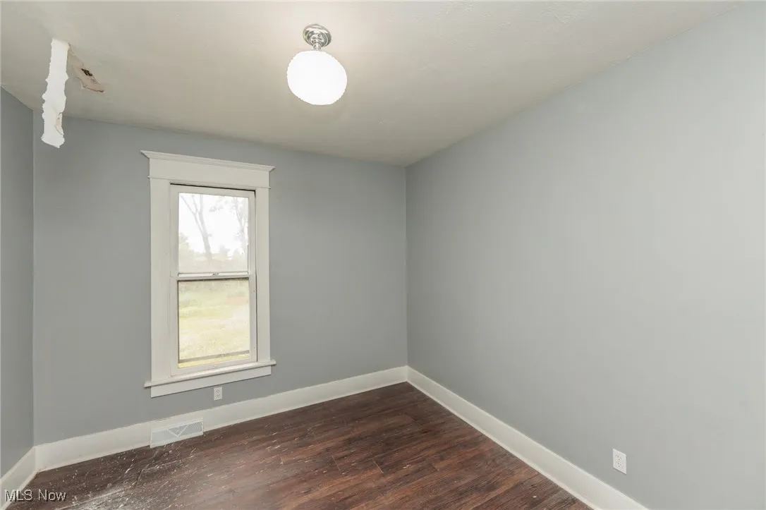 Spare room with dark wood-style floors