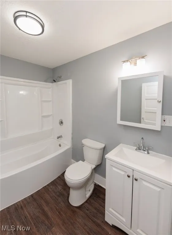 Bathroom with wood finished floors, vanity, and  shower combination