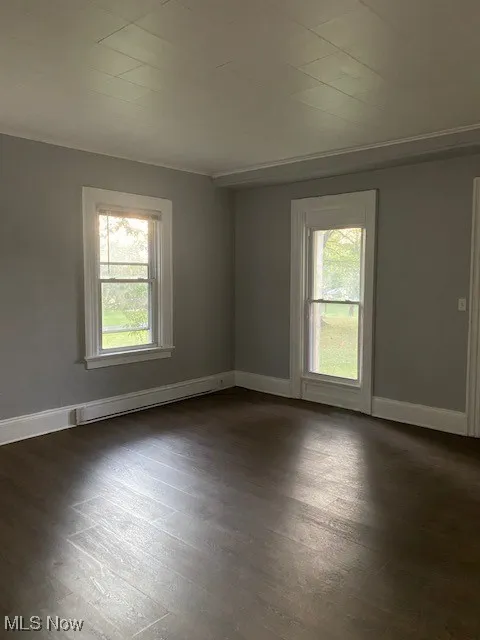 Empty room with dark wood-style flooring