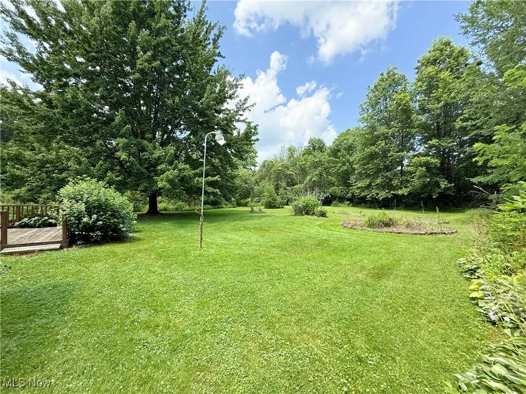 View of grassy yard featuring a deck