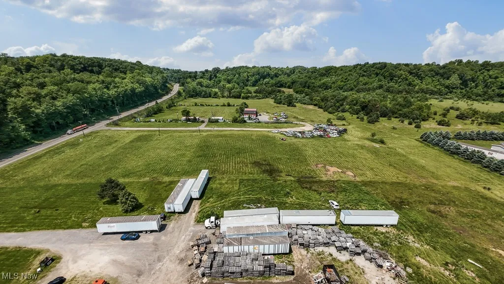 Aerial overview of property's location featuring rural landscape and a forest