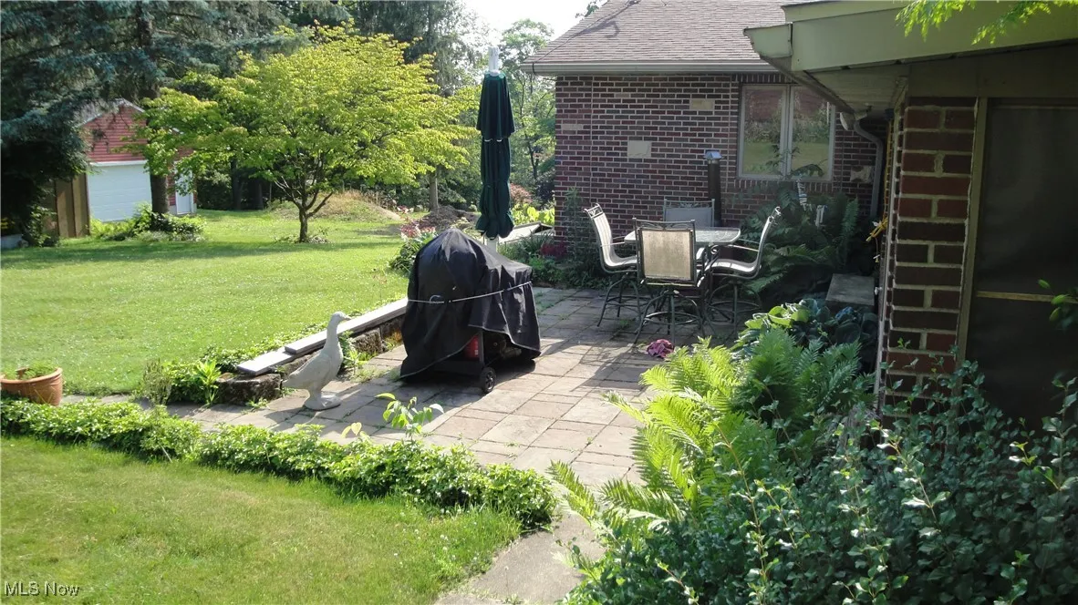 View of grassy yard featuring a patio
