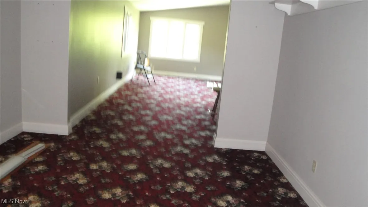 Carpeted empty room with baseboards