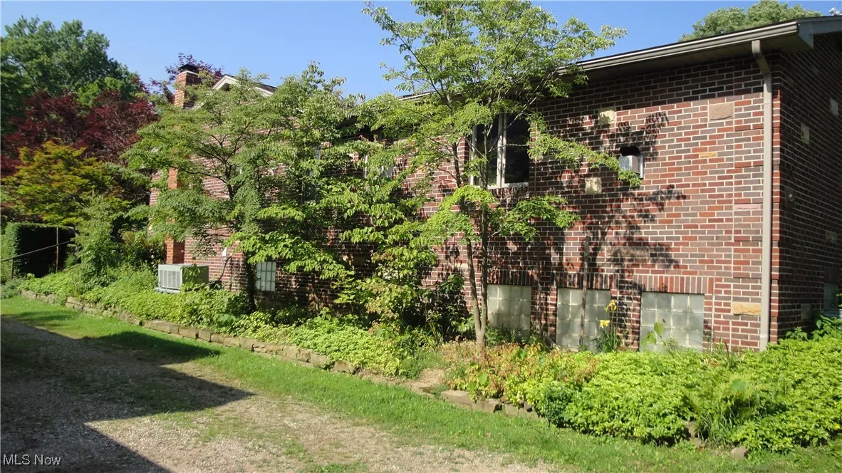 View of side of property with brick siding and a chimney