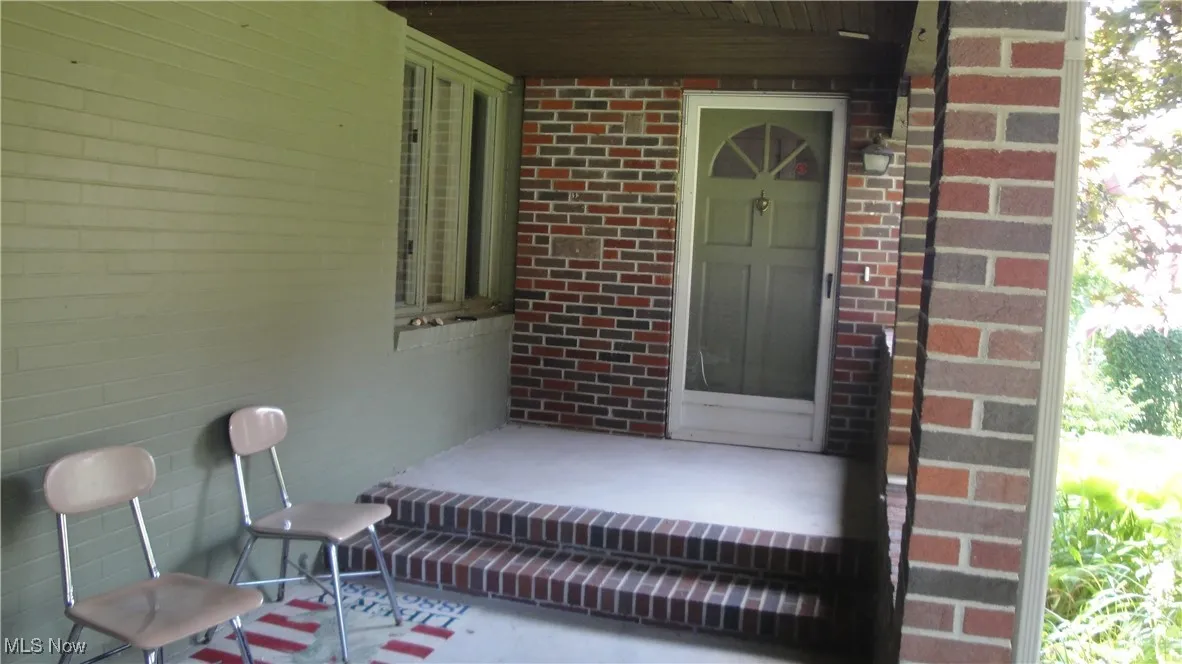 View of exterior entry with brick siding