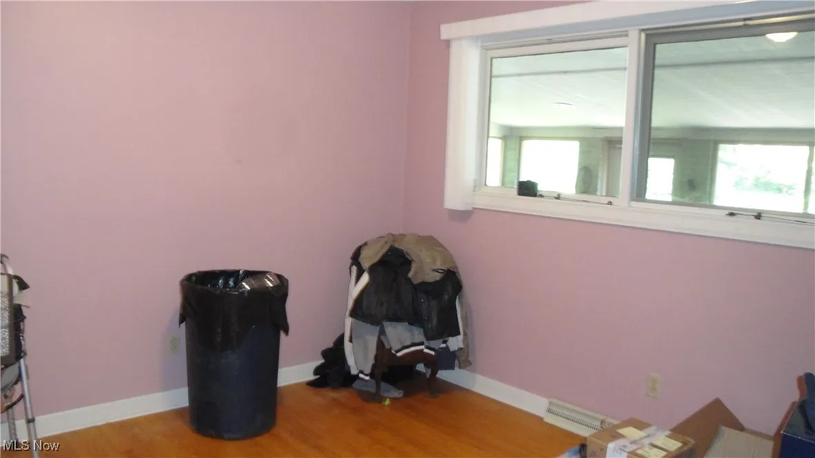 Unfurnished room with wood finished floors and baseboards
