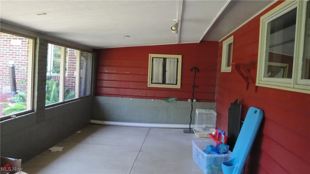 Unfurnished sunroom featuring rail lighting and vaulted ceiling
