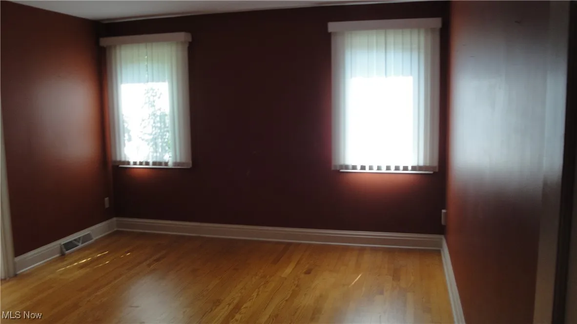 Unfurnished room featuring wood finished floors and baseboards