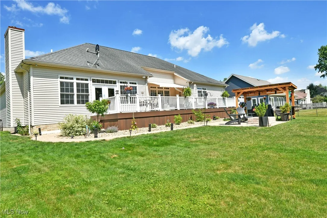 Rear view of house with a chimney, a fenced backyard, a patio, a deck, and a pergola
