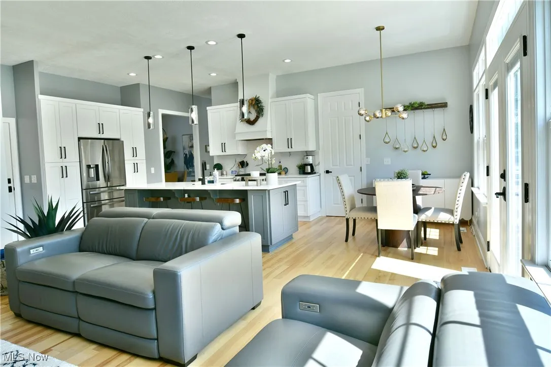 Living room with light wood finished floors, recessed lighting, and a chandelier