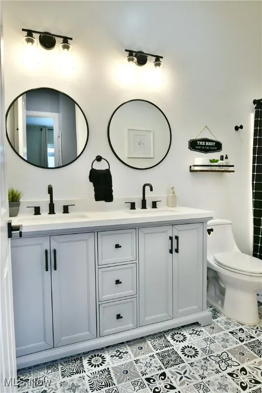 Full bathroom featuring double vanity and tile patterned flooring