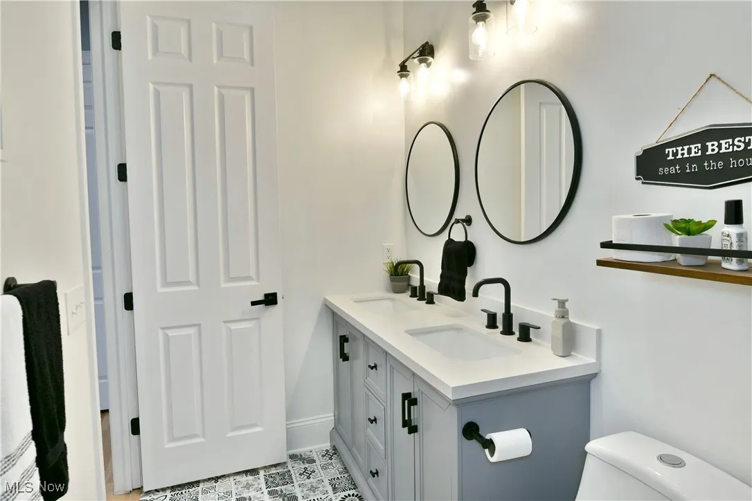 Bathroom featuring double vanity and toilet