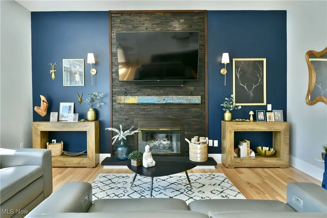 Living area with wood finished floors and a stone fireplace