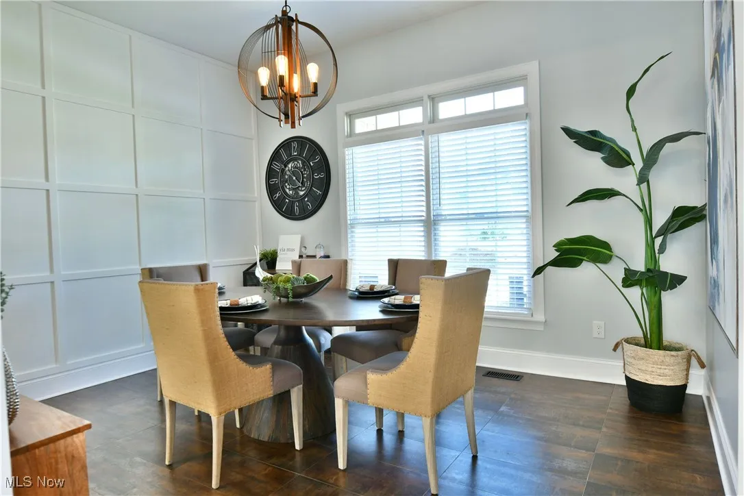 Dining space featuring a chandelier, plenty of natural light, and dark wood-type flooring
