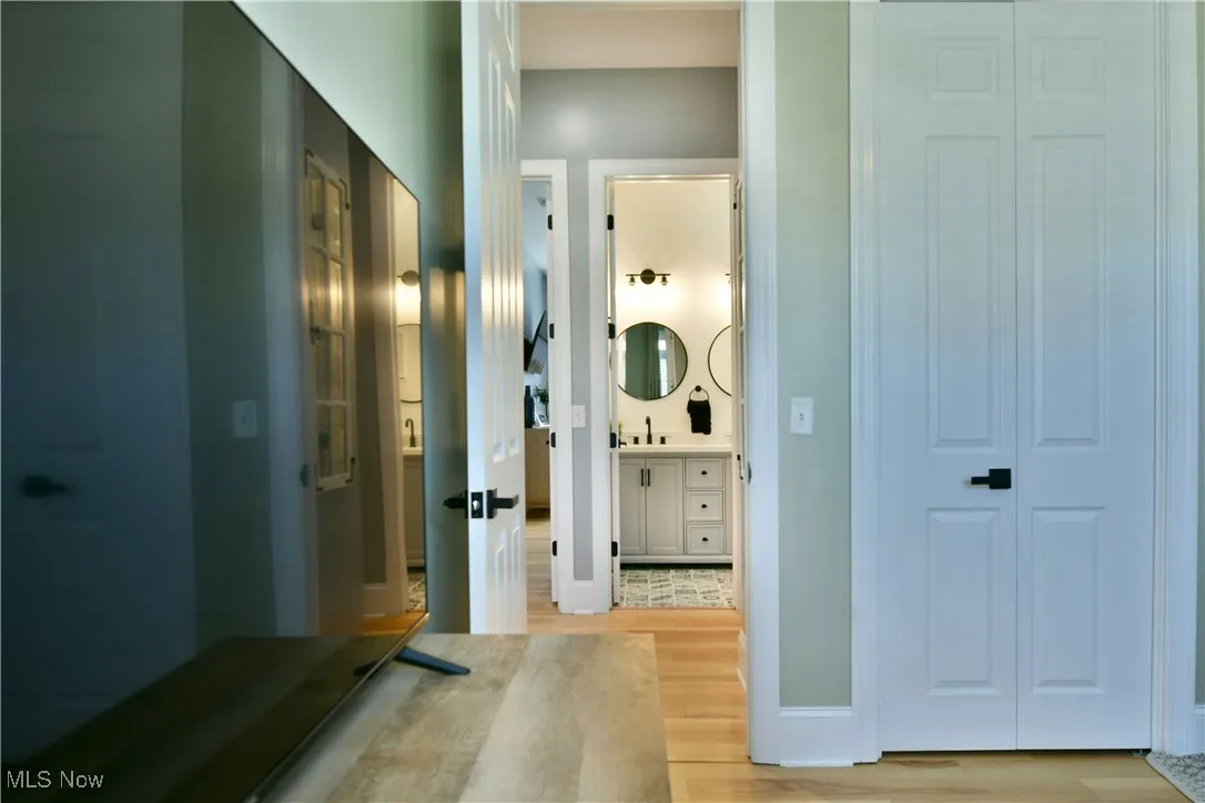 Corridor with light wood-style flooring and a sink