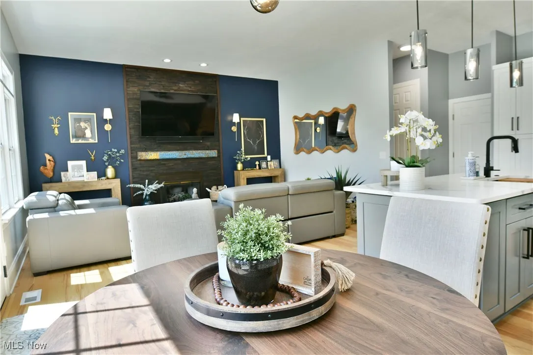 Dining area featuring light wood-type flooring, recessed lighting, and a fireplace