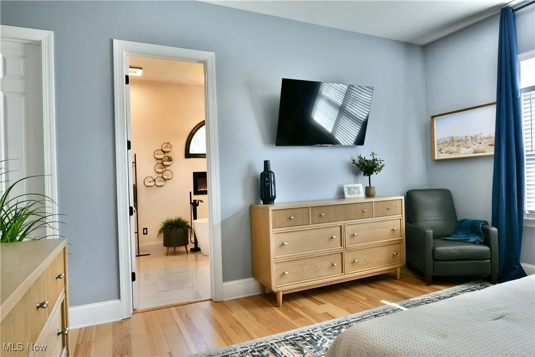 Bedroom with light wood-type flooring and ensuite bathroom