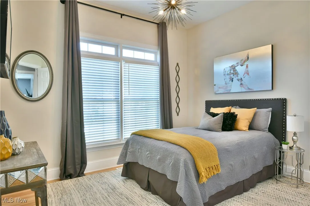 Bedroom featuring wood finished floors and a chandelier