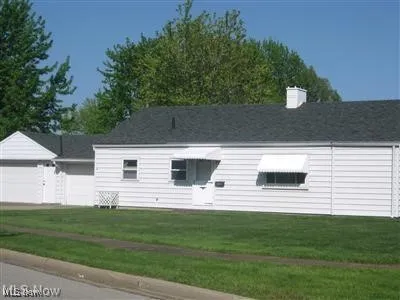 View of front of property with a garage and a front lawn
