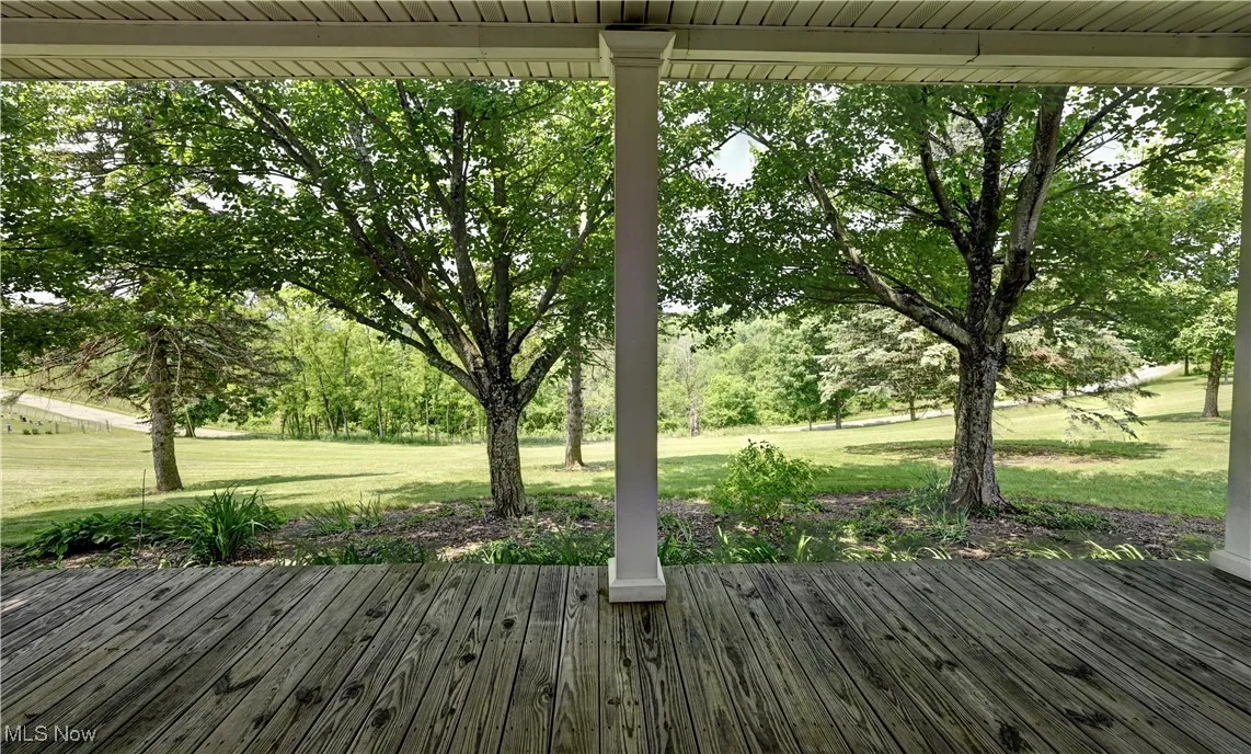 Deck with a lawn and view of scattered trees