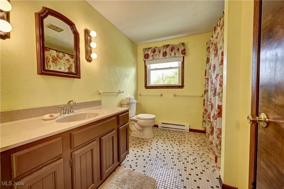 Bathroom with a baseboard heating unit and vanity