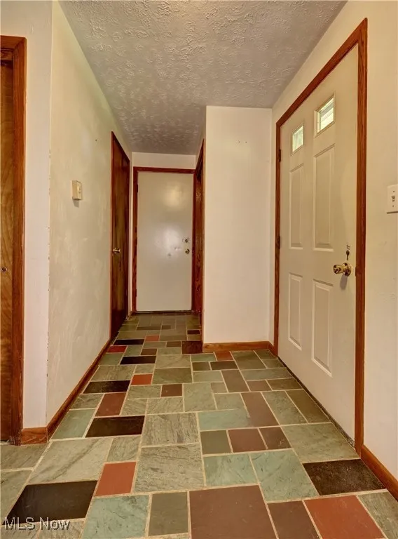 Entrance foyer featuring stone finish floors and a textured ceiling
