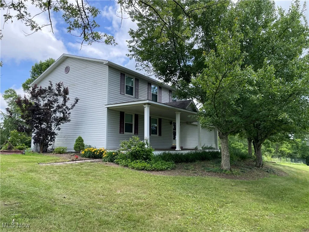 View of front of property with a porch and a front lawn