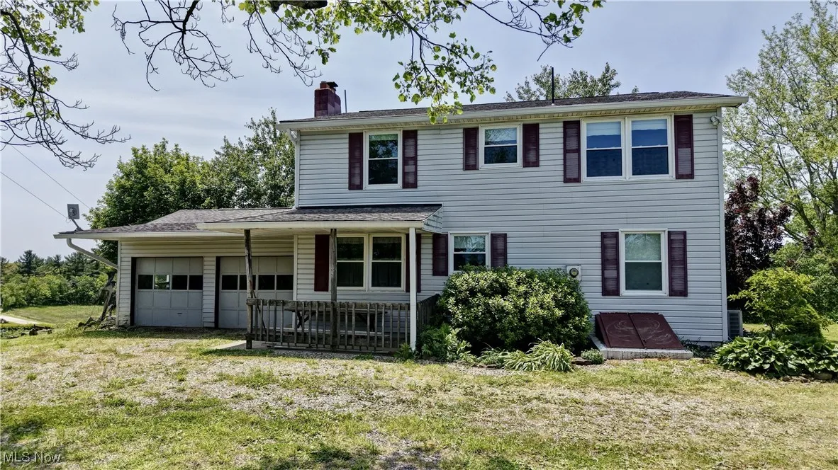 View of front of home featuring a chimney, a front yard, and an attached garage